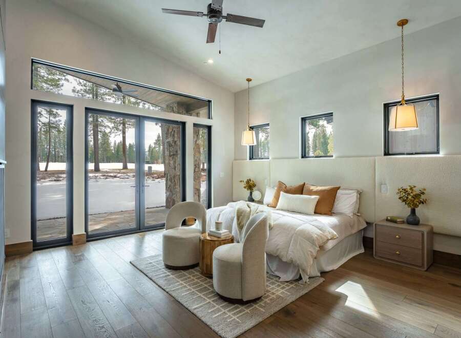 Experience the epitome of luxury in this stunning bedroom, boasting expansive windows that frame breathtaking views of a snow-covered landscape.
