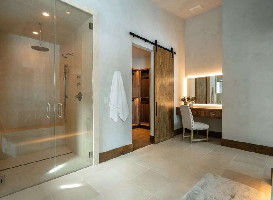 Step into luxury with this stunning bathroom, featuring a spacious glass-enclosed shower and elegant vanity area.
