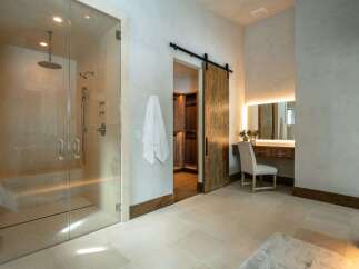 Step into luxury with this stunning bathroom, featuring a spacious glass-enclosed shower and elegant vanity area.