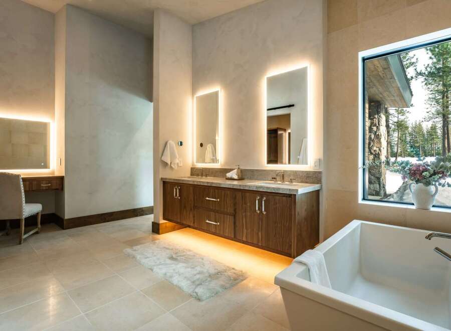 Step into luxury with this stunning bathroom, featuring a sleek double vanity with illuminated mirrors and a modern soaking tub.
