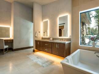 Step into luxury with this stunning bathroom, featuring a sleek double vanity with illuminated mirrors and a modern soaking tub.