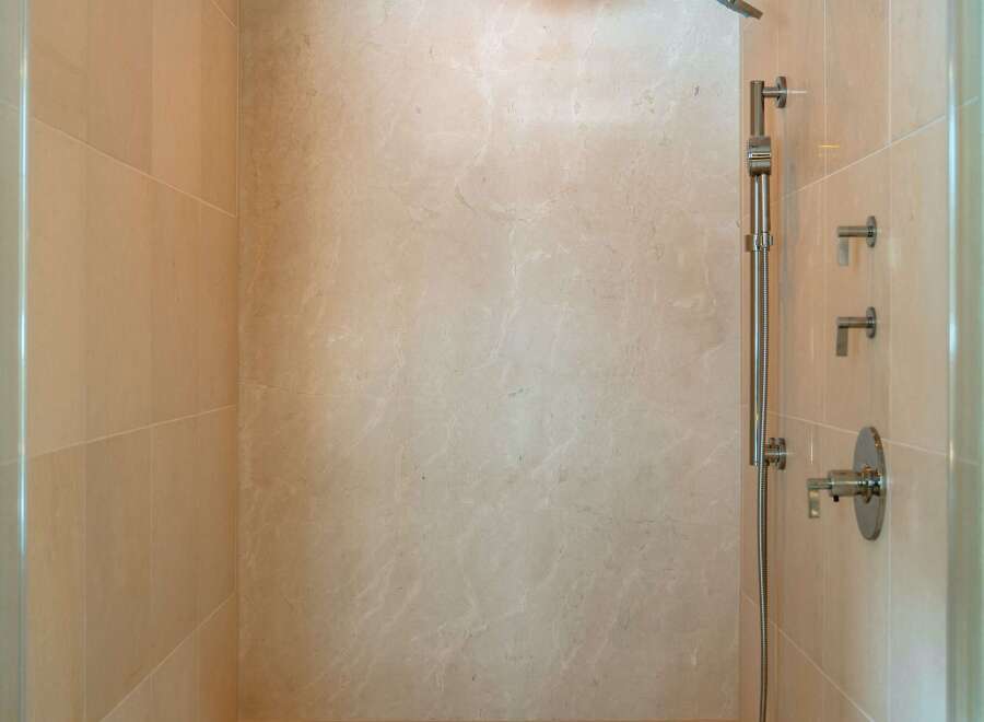 Step into luxury with this stunning shower featuring elegant tile work and a built-in bench.