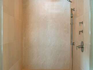 Step into luxury with this stunning shower featuring elegant tile work and a built-in bench.