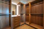 Step into luxury with this stunning walk-in closet, featuring custom wood cabinetry and ample storage space.