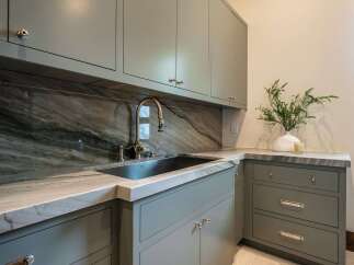 This stunning kitchen boasts a luxurious design with elegant cabinetry and a sleek marble countertop.