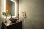 This modern bathroom features a sleek design with a dark countertop and a stylish vessel sink.