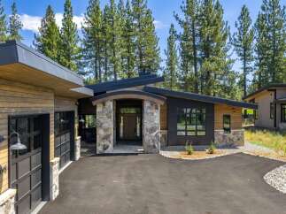 Discover modern mountain living in this stunning home, featuring a striking architectural design with natural wood siding and stone accents.