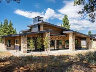 Experience modern mountain living in this stunning home featuring natural wood siding and striking stone accents.