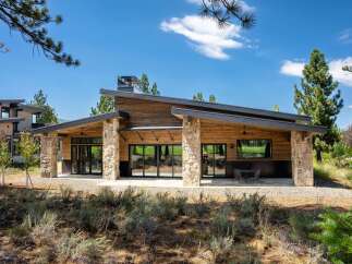 Experience modern mountain living in this stunning home featuring a striking architectural design with natural wood siding and stone accents.