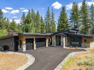 Experience modern mountain living in this stunning home featuring a striking architectural design with natural stone accents and warm wood siding.