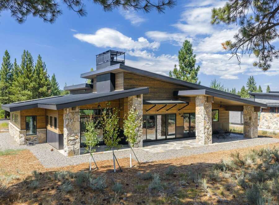 Experience modern mountain living in this stunning architectural home, featuring a striking blend of natural stone and warm wood siding.
