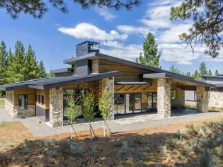 Experience modern mountain living in this stunning architectural home, featuring a striking blend of natural stone and warm wood siding.