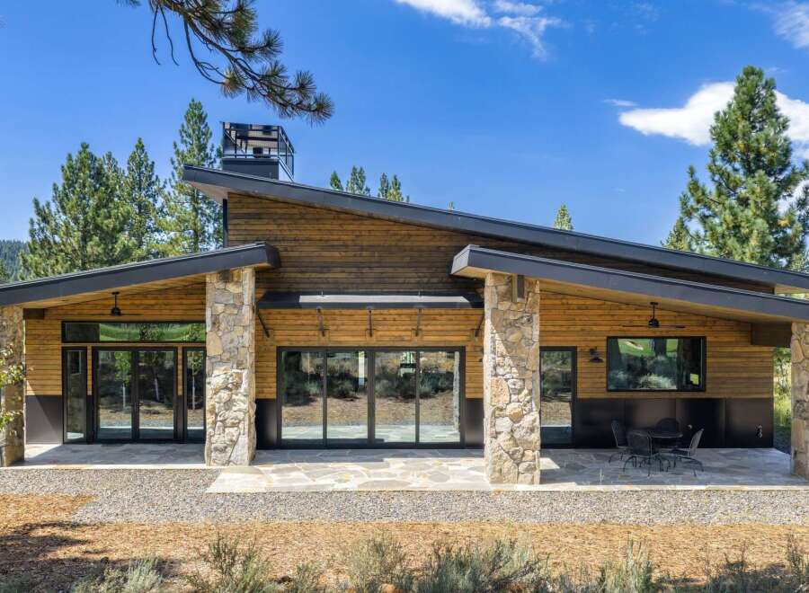 Experience modern mountain living in this stunning home featuring a striking asymmetrical roofline and natural stone accents.