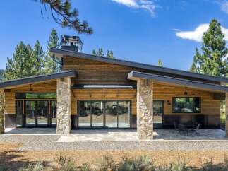 Experience modern mountain living in this stunning home featuring a striking asymmetrical roofline and natural stone accents.