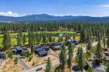 Experience luxury living adjacent to a pristine golf course, surrounded by a dense forest of mature pine trees.