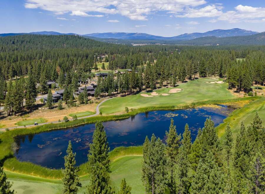 Experience luxury living amidst a stunning golf course setting, featuring a serene lake and lush green fairways.