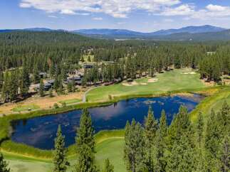 Experience luxury living amidst a stunning golf course setting, featuring a serene lake and lush green fairways.