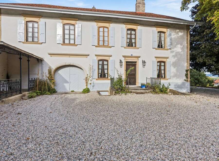 Discover this charming property featuring a classic facade with light grey shutters and decorative stone accents.