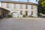 Discover this charming property featuring a classic facade with light grey shutters and decorative stone accents.