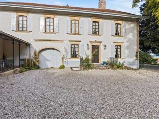 Discover this charming property featuring a classic facade with light grey shutters and decorative stone accents.