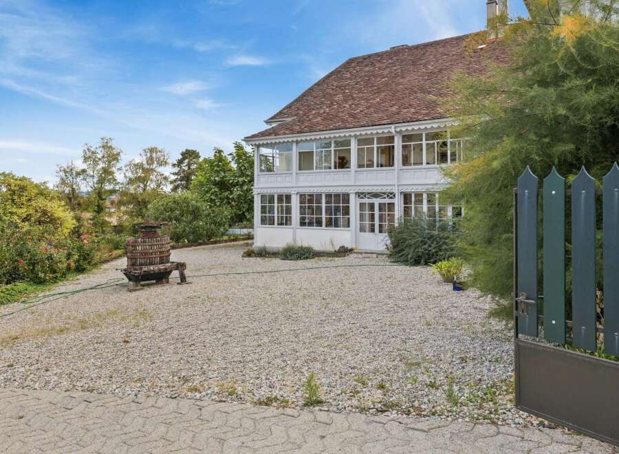 Discover this charming property featuring a classic white house with a distinctive sunroom, perfect for enjoying natural light year-round.