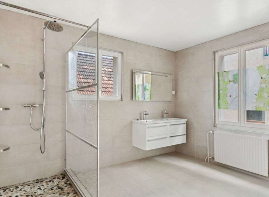 Step into this modern bathroom featuring a spacious walk-in shower with a glass enclosure.