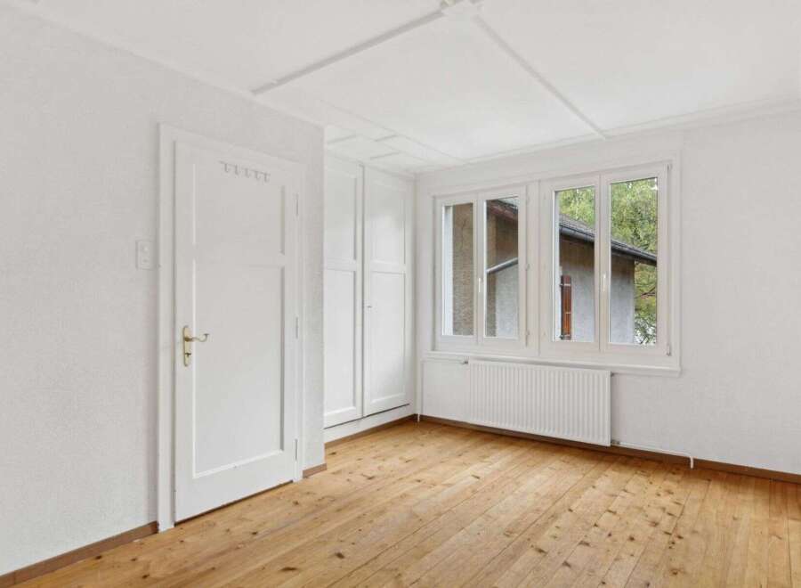 This bright and airy room features beautiful hardwood floors and crisp white walls, creating a clean and inviting atmosphere.