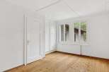 This bright and airy room features beautiful hardwood floors and crisp white walls, creating a clean and inviting atmosphere.