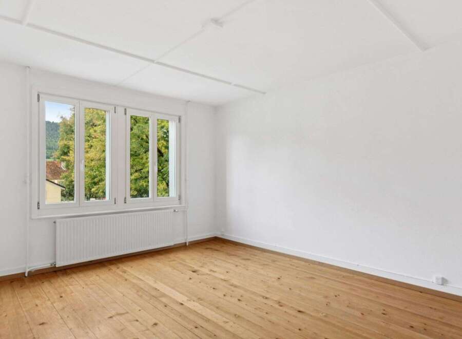 Bright and airy room featuring a large window that offers stunning views of the surrounding nature.