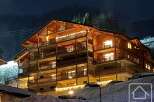 Experience luxury living in this stunning chalet-style property, featuring multiple levels of spacious balconies and warm wooden accents.