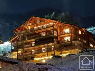 Experience luxury living in this stunning chalet-style property, featuring multiple levels of spacious balconies and warm wooden accents.