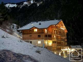 Discover a stunning alpine property nestled in a snowy landscape, perfect for a luxurious retreat.