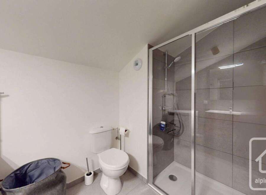 Discover a modern bathroom with a sleek shower enclosure and contemporary fixtures.