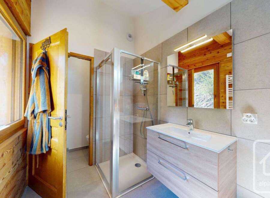 This stunning bathroom features a modern shower, a stylish vanity, and a large mirror, creating a spa-like atmosphere.