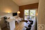 Discover this charming property featuring a cozy living space with a comfortable sofa and a dining area.