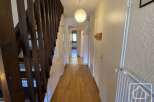 Discover this inviting property featuring a well-lit hallway with wooden flooring and a staircase.
