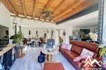 Discover the charm of this stunning property, featuring a beautifully designed living space with a rustic wooden ceiling and elegant flooring.