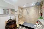 Discover a unique bathroom design featuring a rustic barrel sink and a modern glass shower.