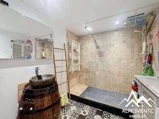 Discover a unique bathroom design featuring a rustic barrel sink and a modern glass shower.
