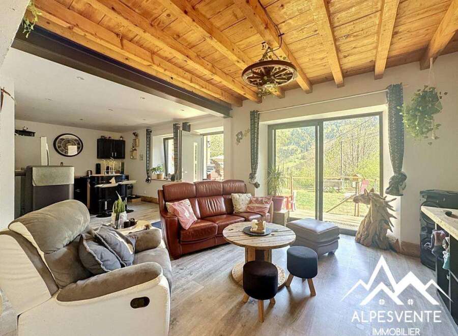 Discover the charm of this stunning property, featuring a cozy living area with a rustic wooden ceiling and a comfortable leather sofa.
