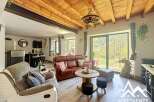 Discover the charm of this stunning property, featuring a cozy living area with a rustic wooden ceiling and a comfortable leather sofa.