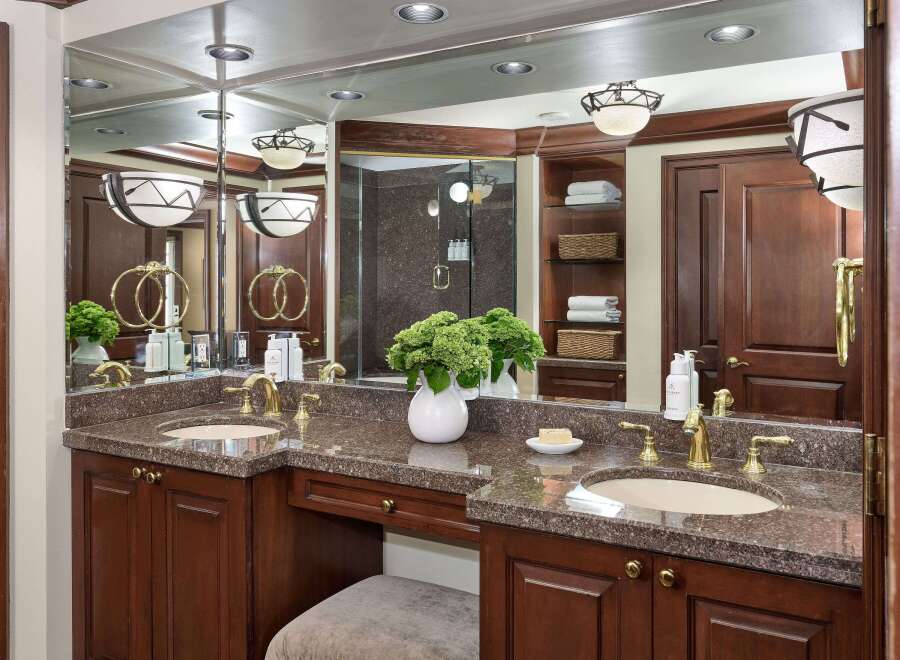 This luxurious bathroom boasts a stunning vanity with a granite countertop and elegant gold fixtures.