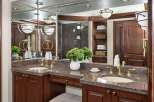 This luxurious bathroom boasts a stunning vanity with a granite countertop and elegant gold fixtures.