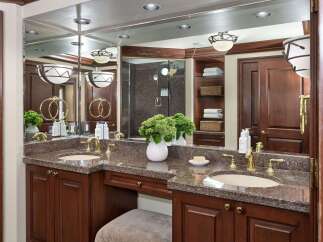 This luxurious bathroom boasts a stunning vanity with a granite countertop and elegant gold fixtures.