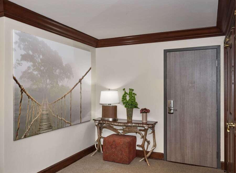 Step into luxury with this stunning entryway, featuring a captivating artwork and a stylish console table.