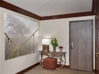 Step into luxury with this stunning entryway, featuring a captivating artwork and a stylish console table.