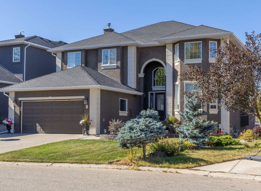 This stunning property boasts a modern design with a dark exterior and elegant white trim.