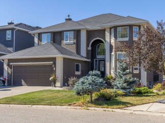 This stunning property boasts a modern design with a dark exterior and elegant white trim.