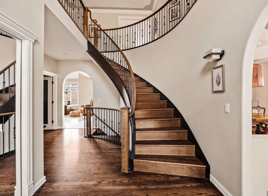This stunning property boasts a grand, curved staircase, a focal point of the elegant entryway.