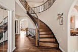 This stunning property boasts a grand, curved staircase, a focal point of the elegant entryway.